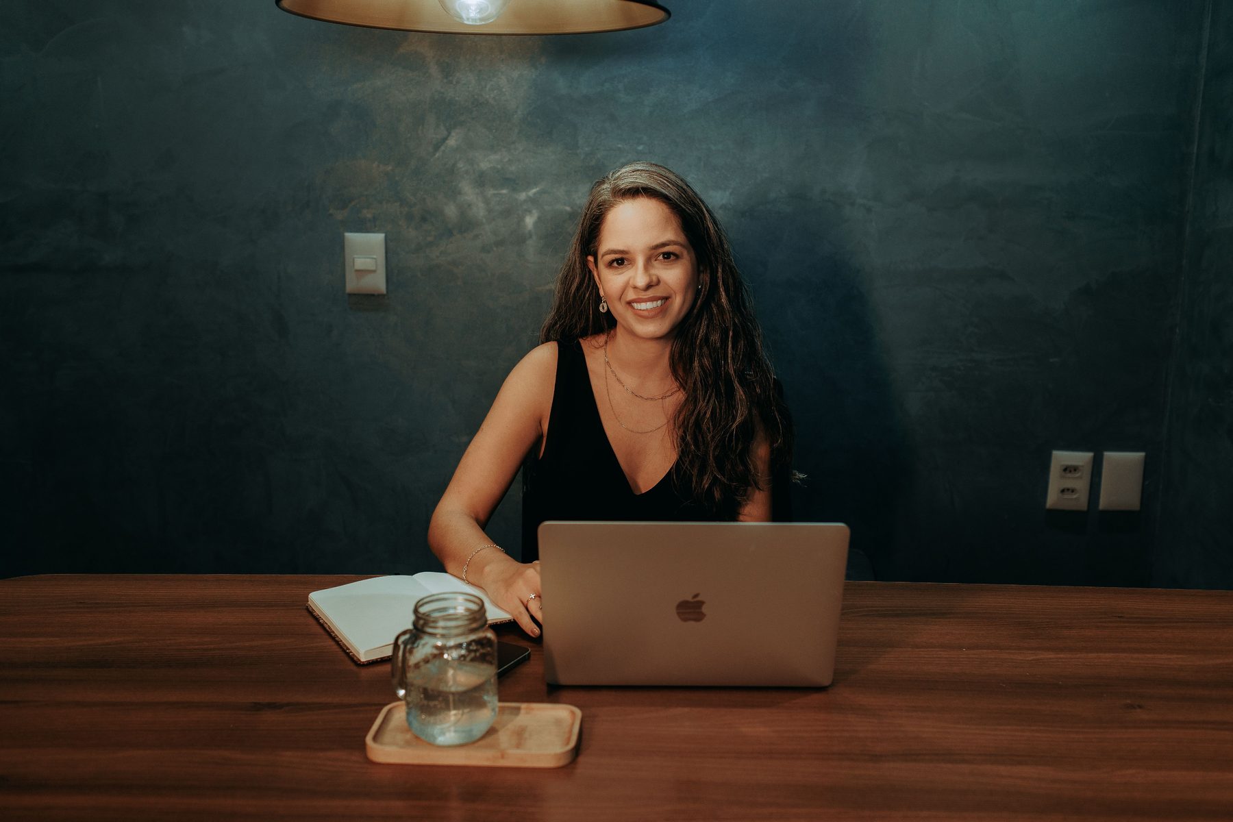 Smiling applicant completing an online application on a laptop
